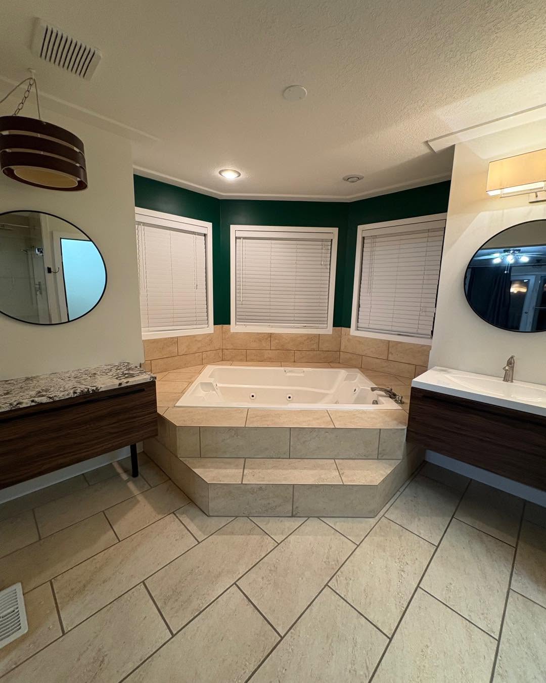 Sunken tiled jacuzzi tub and floating vanities