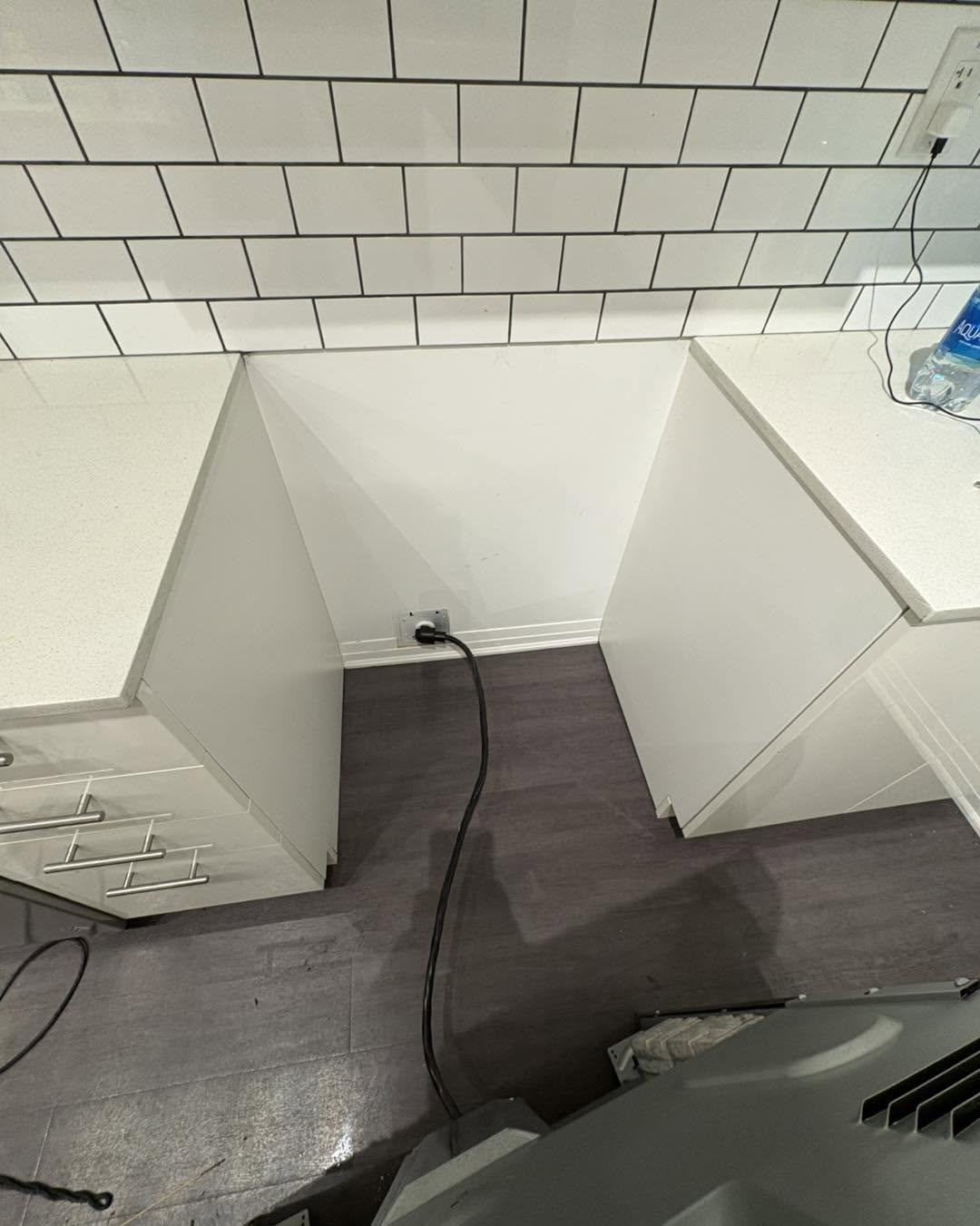 Clean floor and cabinetry base after stove pulled out