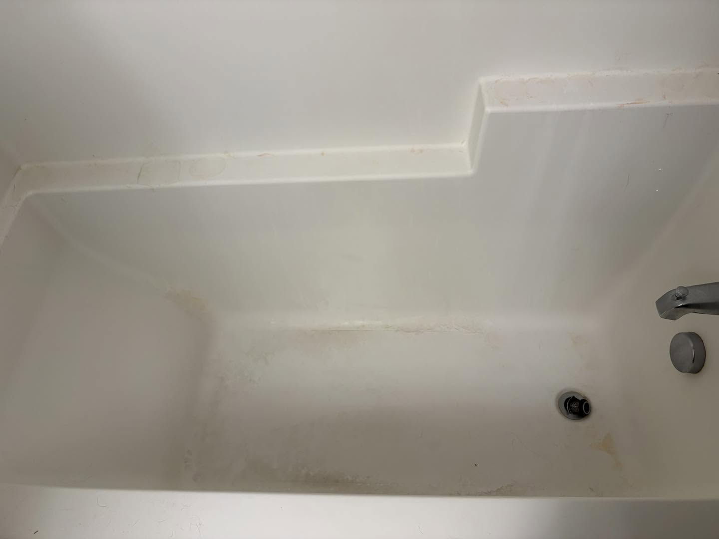 Bathtub waterline mineral buildup before restoration